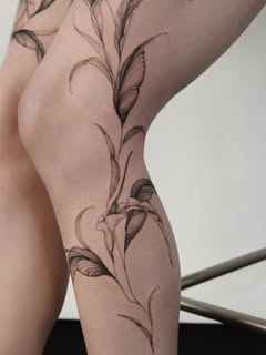 Filigranes botanisches Fine-Line Tattoo am Bein