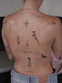 Mehrere kleine fein gesetzte Tattoo-Motive auf dem Rücken
